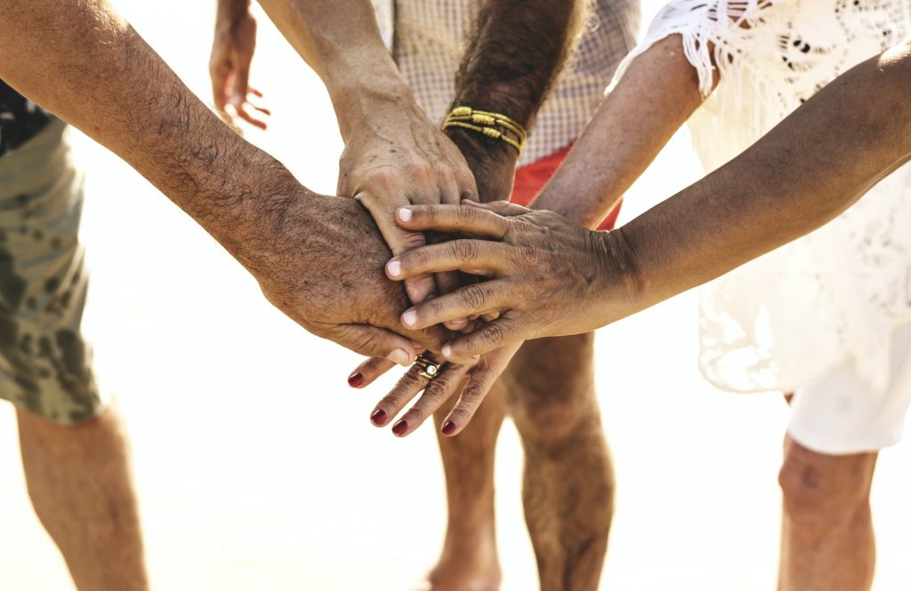 Group of senior friends stacking hands