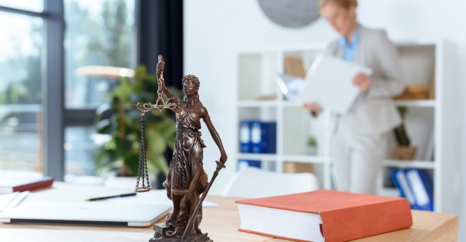 bronze themis sculpture on female lawyer table
